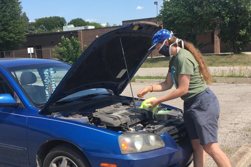 Mechanic checks a car’s oil level.